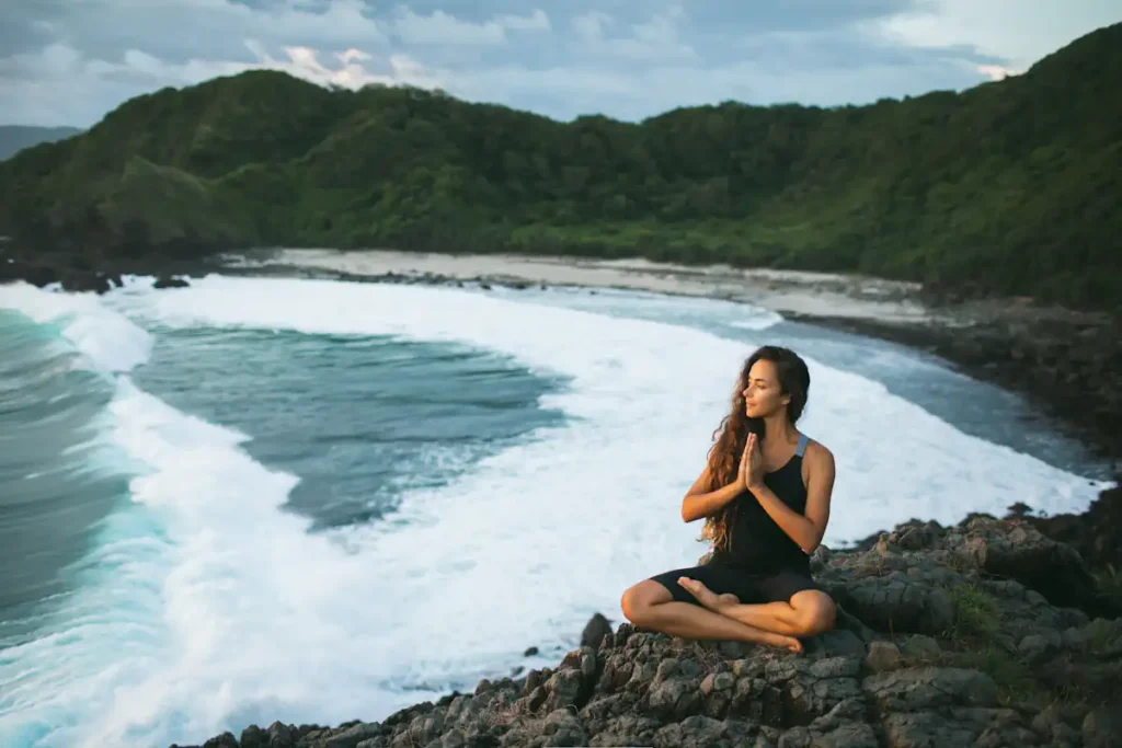 Une femme qui fait de la méditation en bord de mer