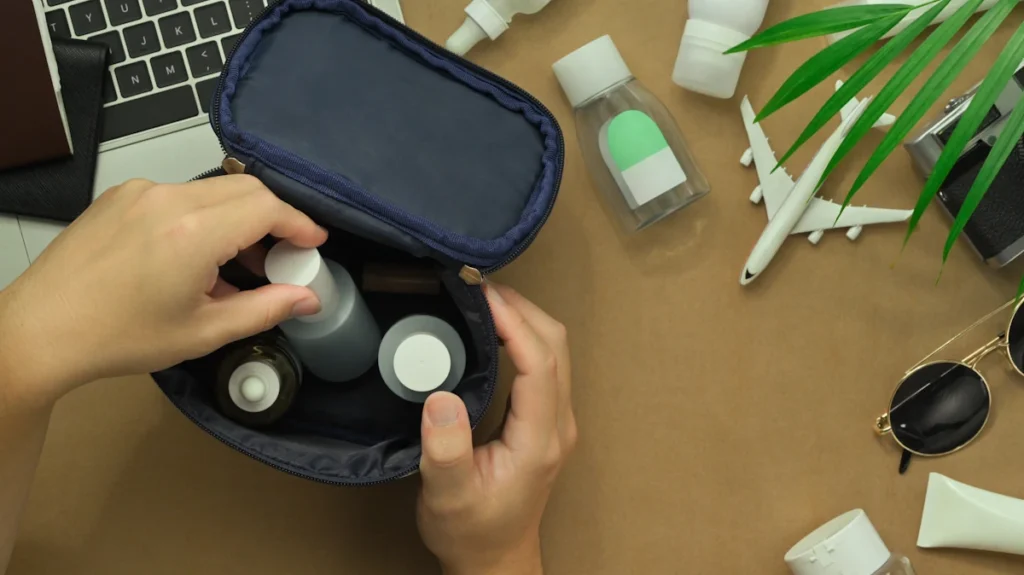 Une personne qui organise une trousse de voyage avec différents produits