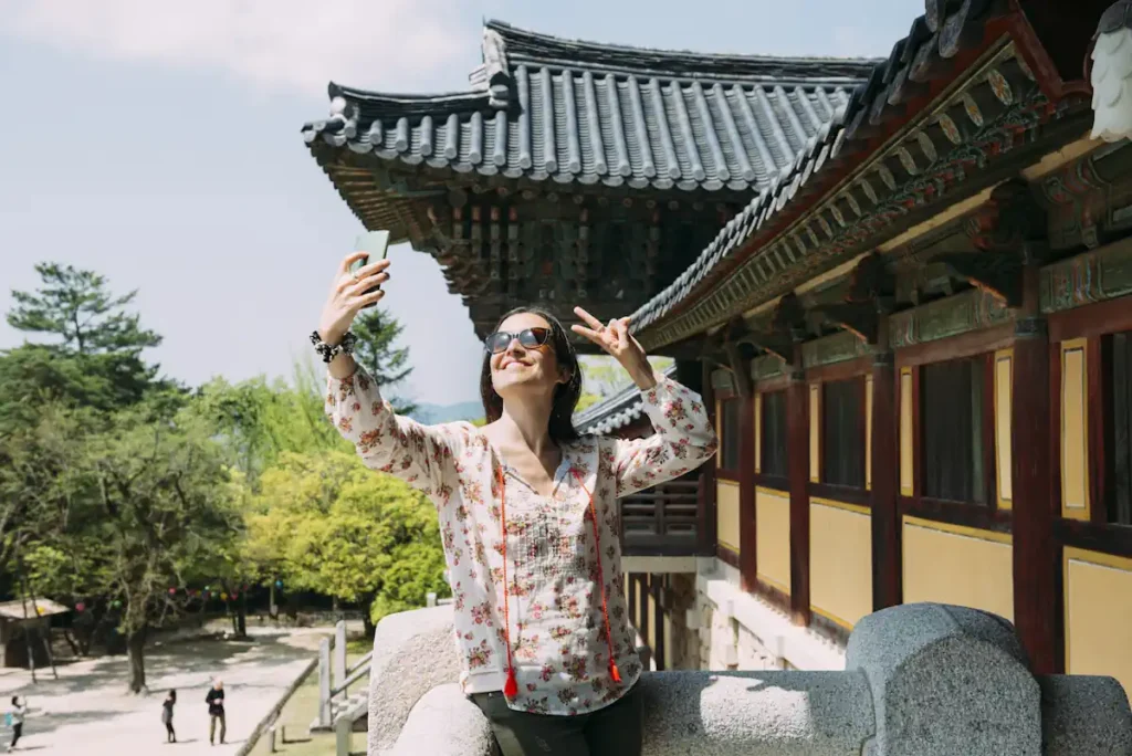 Une femme qui prend un selfie devant un temple