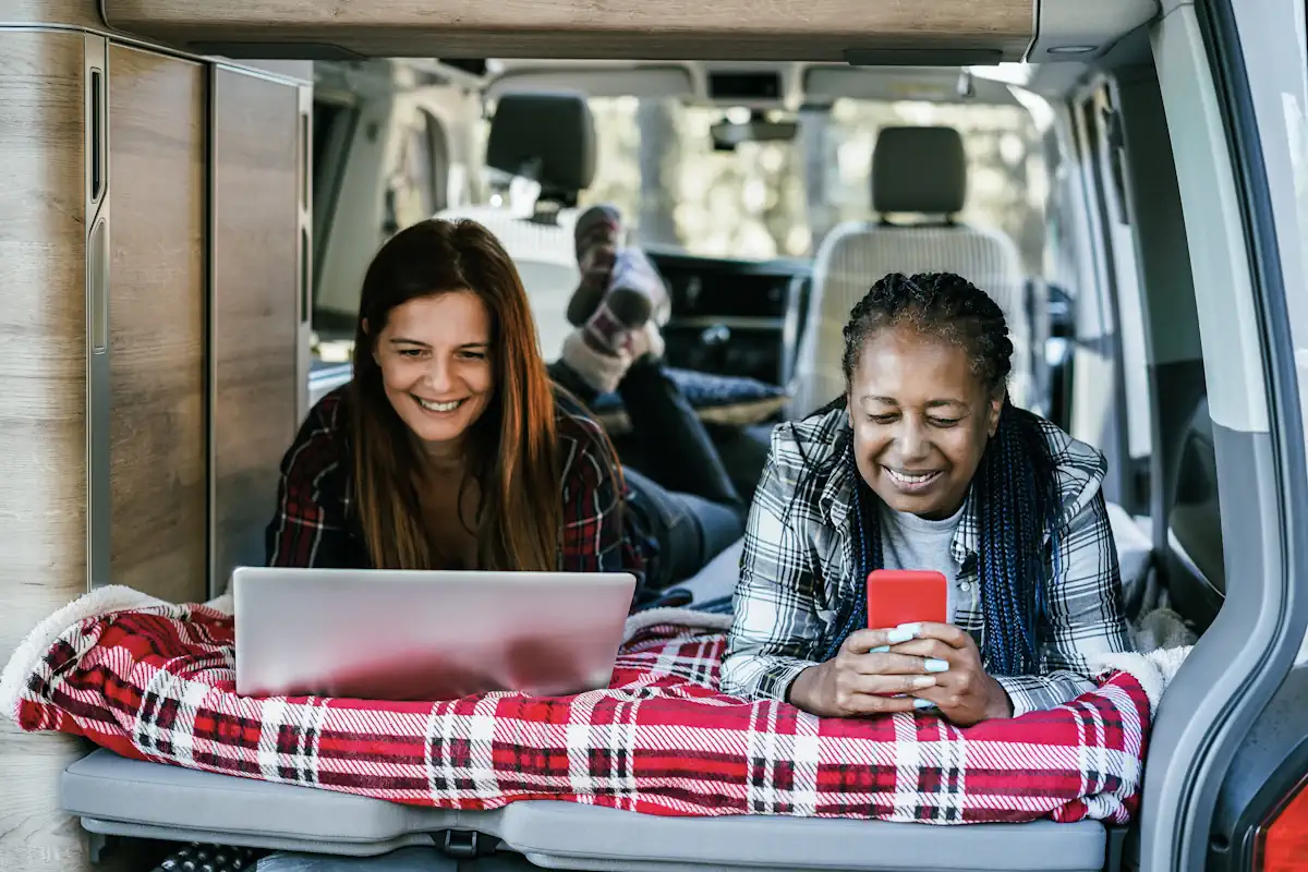 Un couple dans un camping car qui se connecte sur leur ordinateur t smartphone