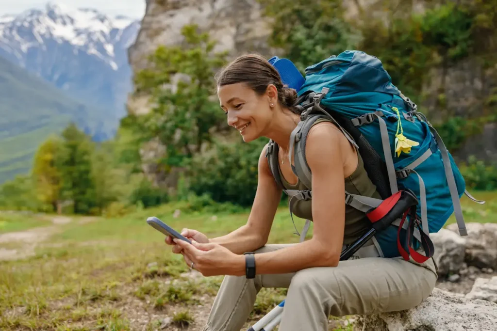 Une femme su rune appli en pleine randonnée