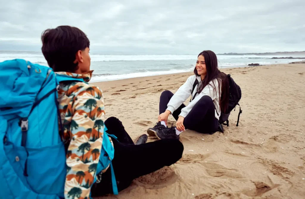 deux voyageurs qui discutent sur la plage