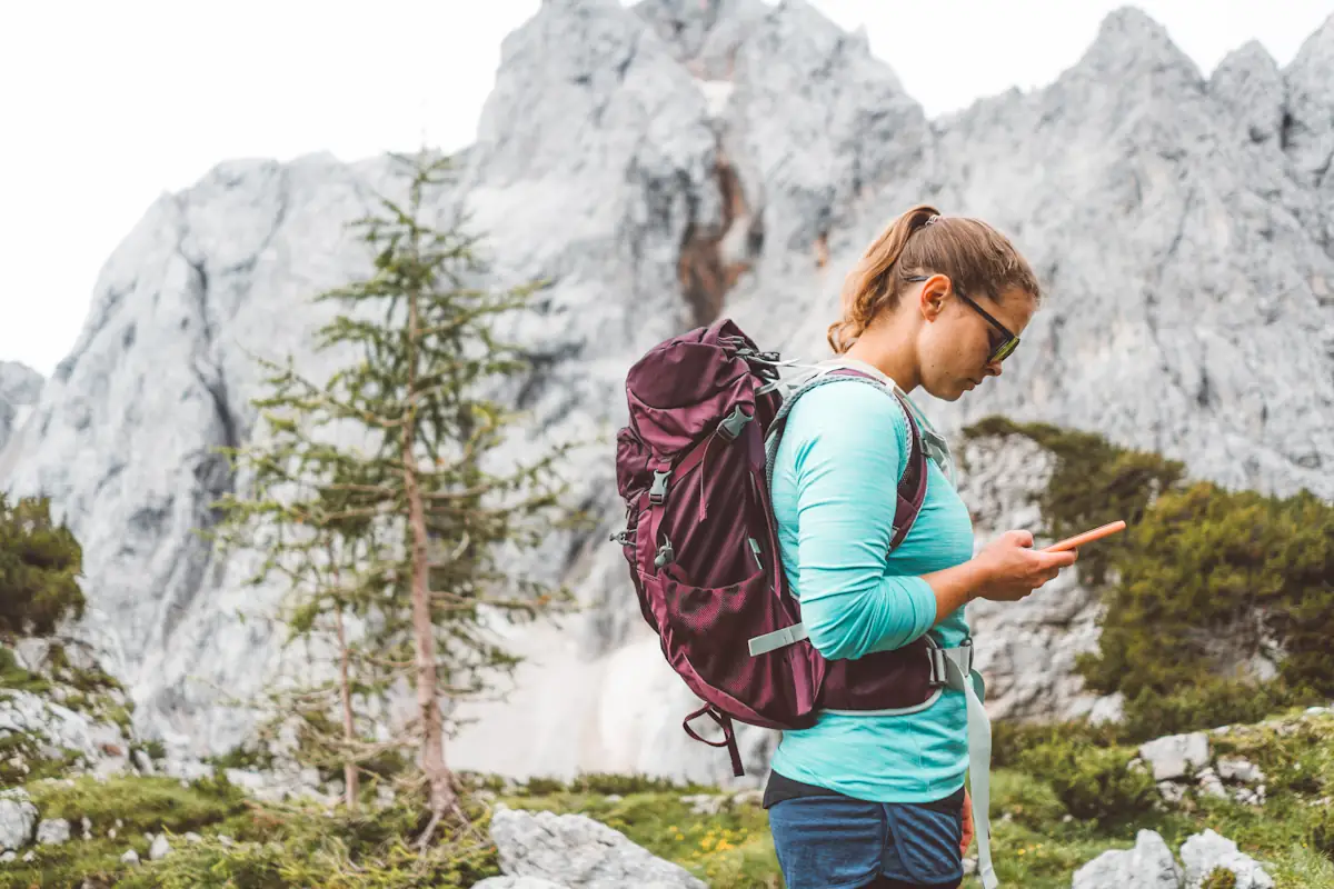 Une femme en randonnée seule avec son téléphone