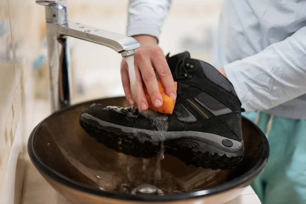 Une personne qui nettoie ses chaussures de randonnées