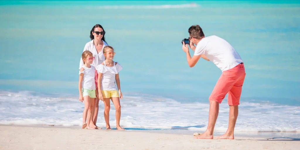 Un homme qui prend en photo une famille à la plage