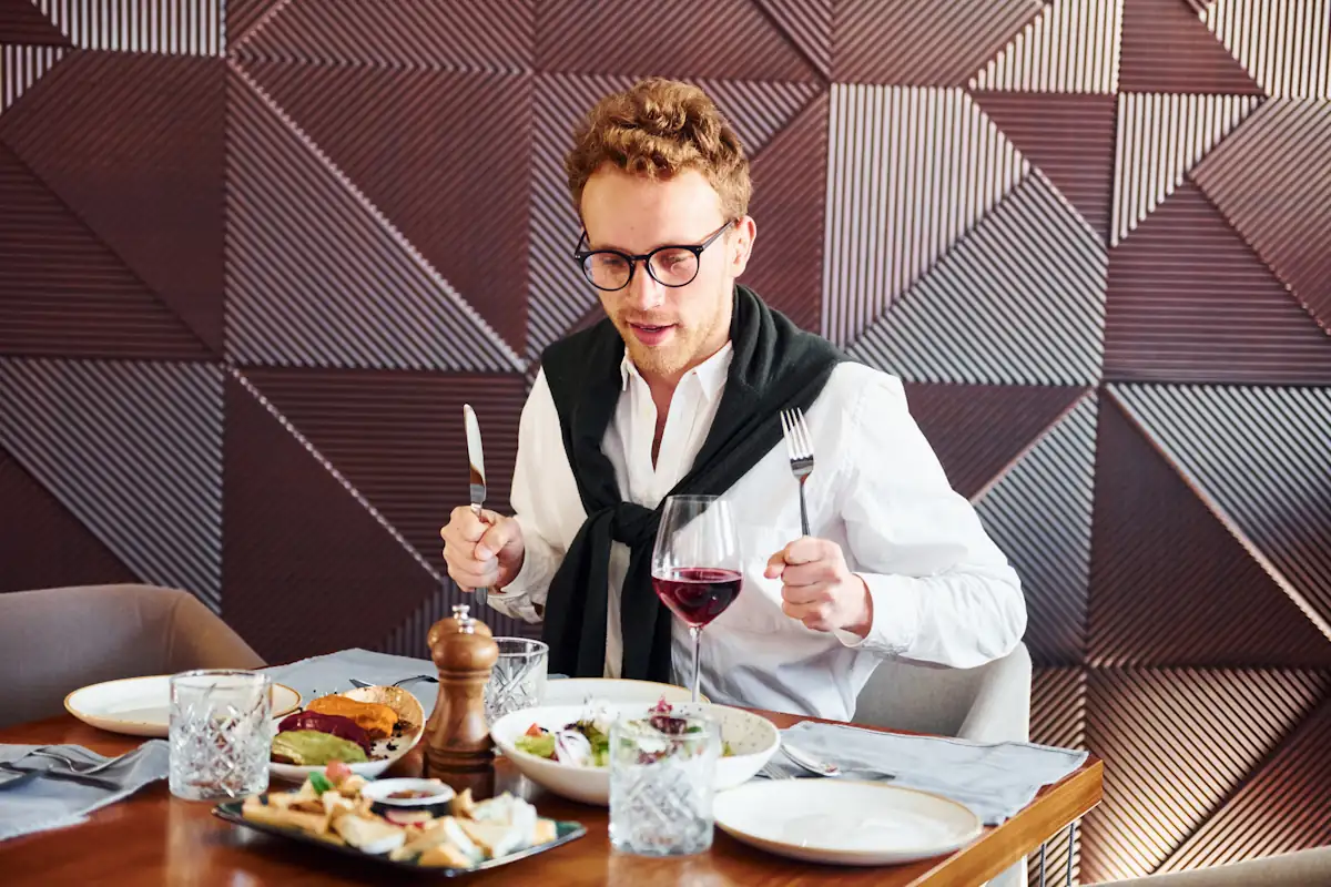 Un homme qui mange seul dan un restaurant gastronomique