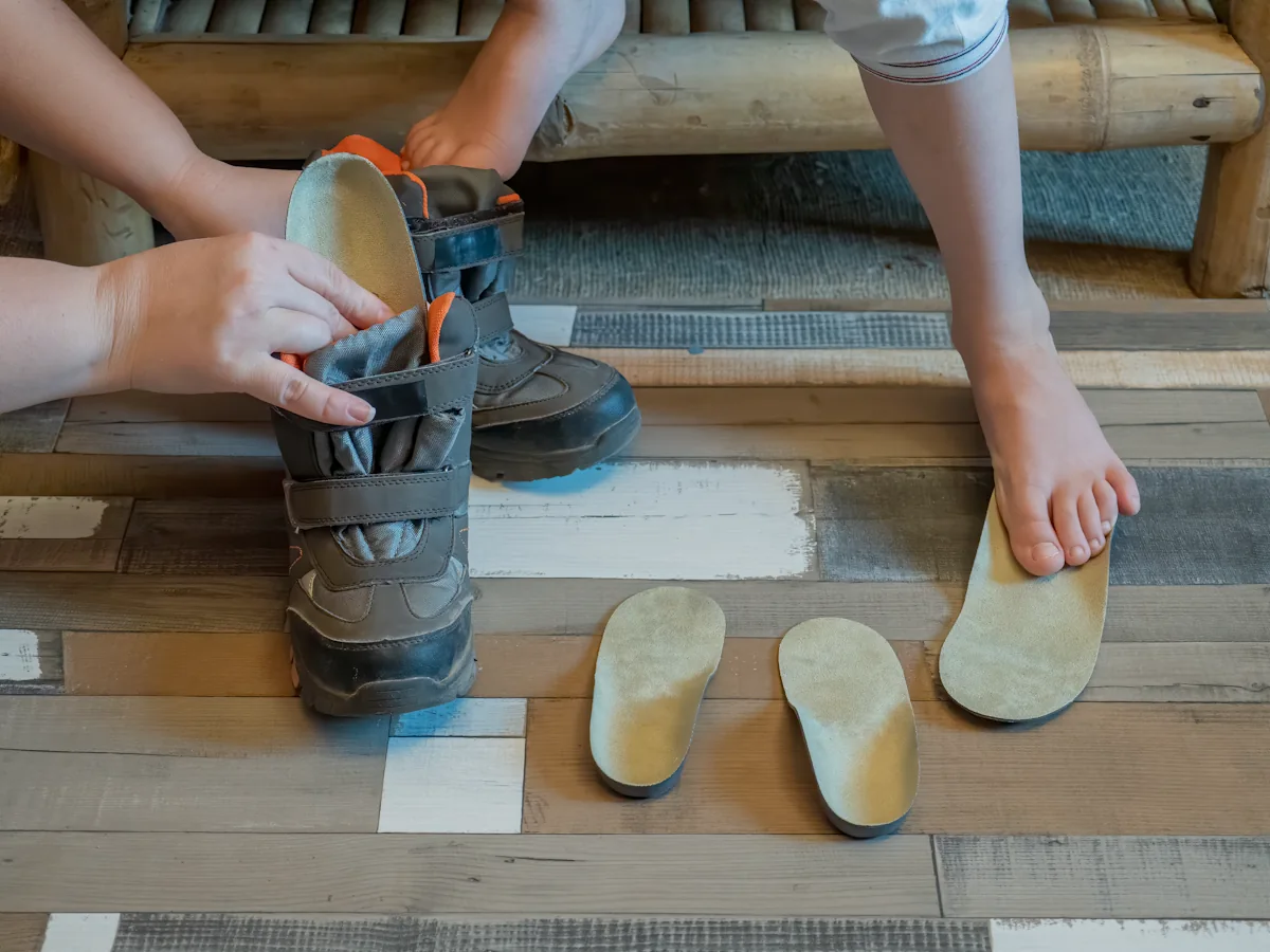 Une personne qui retire les semelles intérieures d'une chaussure de randonnée